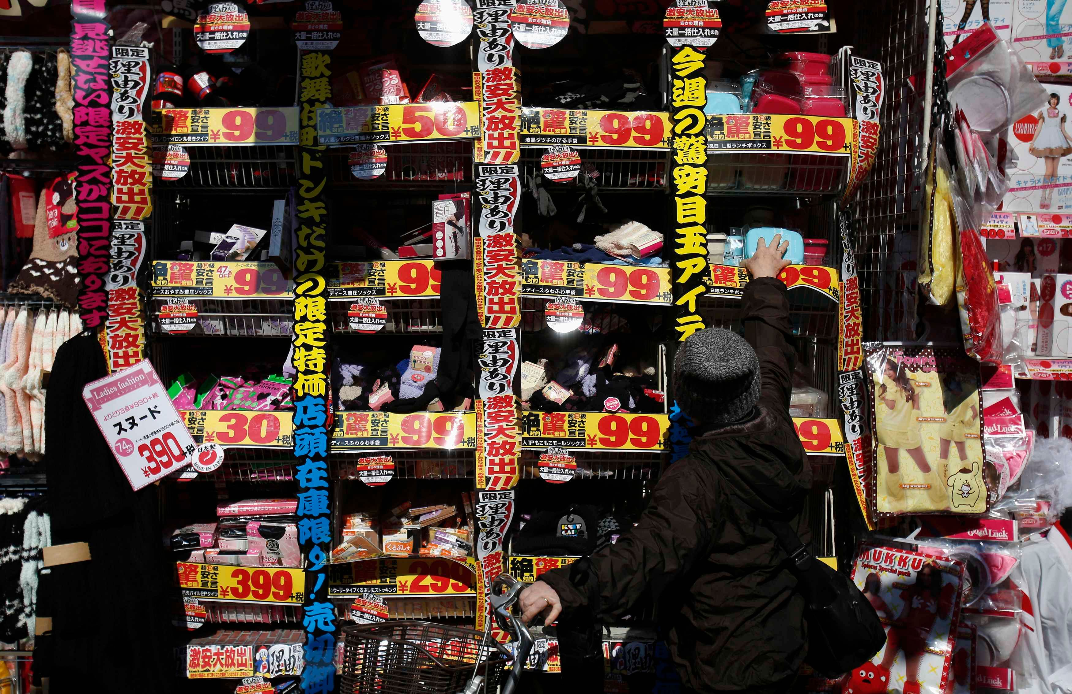 A woman reaches for an item displayed outside a discount store in Tokyo February 15, 2015. Japan's economy rebounded from recession to grow an annualised 2.2 percent in the final quarter of last year, giving a much-needed boost to premier Shinzo Abe's efforts to shake off decades of stagnation even as the global outlook deteriorates. Photo: Reuters