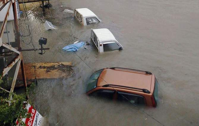 Stranded cars are seen in floodwater caused by Typhoon Halong in Kochi, western Japan in this photo taken by Kyodo August 10, 2014. Typhoon Halong killed one person in Japan on Sunday and injured 33, media said, as authorities ordered 1.6 million people out of the path of the storm that battered the west of the country with heavy rain and wind. Photo: Reuters
