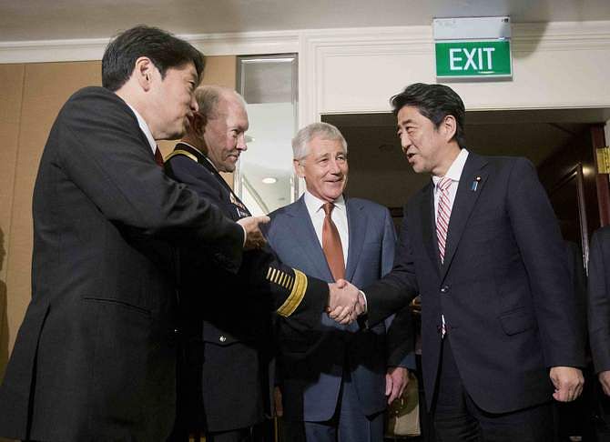 Japanese Defense Minister Itsunori Onodera (L) and US Defense Secretary Chuck Hagel (2nd R) look on as US Chairman of the Joint Chiefs of Staff General Martin Dempsey (2nd L) shakes hands with Japanese Prime Minister Shinzo Abe in Singapore May 30, 2014. Photo: Reuters