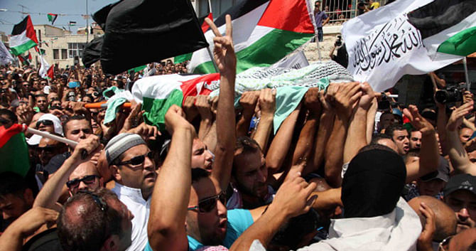 People carry the body of Muhammad Abu Kdear during his funeral ceremony in Jerusalem on July 3. Photo: Getty Images 