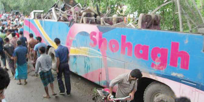 People gather beside a damaged bus of Sohag Paribahan that hit a roadside tree in Jhikorgachha upazila of Jessore Tuesday morning. 10 passengers of it were killed in the road accident. Photo Courtesy: Prothom Alo