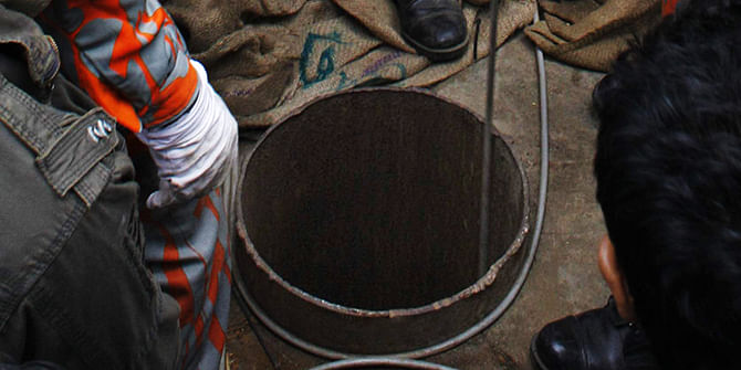A firefighter lowering a cable attached to a claw volunteers had devised to recover four-year-old Jihad from the well at Shahjahanpur Railway Colony in Dhaka Saturday. Photo: Star