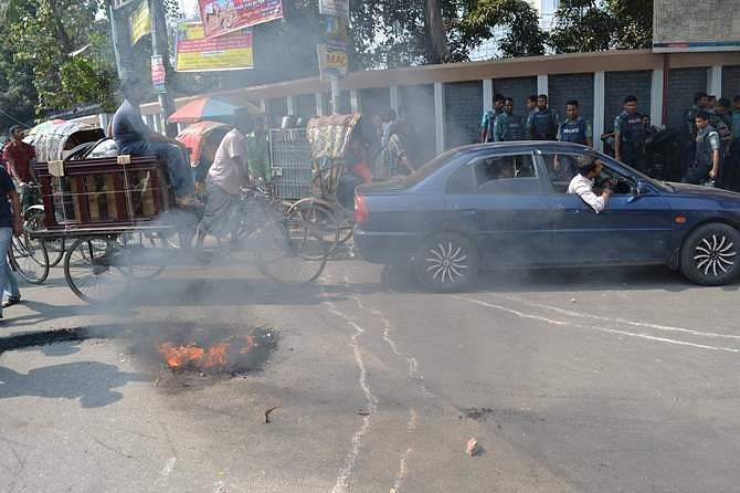 Students of Jagannath University burn wooden materials on the road in front of Jatiya Press Club in the capital during their sit-in programme Monday. The students have been demonstrating since February 12 demanding 