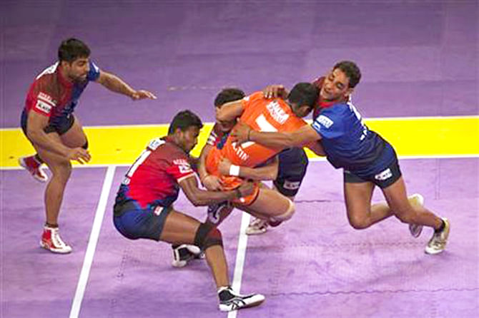 Dabang Delhi players grab a Bengal Warriors player, second from right, during their Pro Kabaddi League match in New Delhi on Aug 6, 2014. Photo: AP