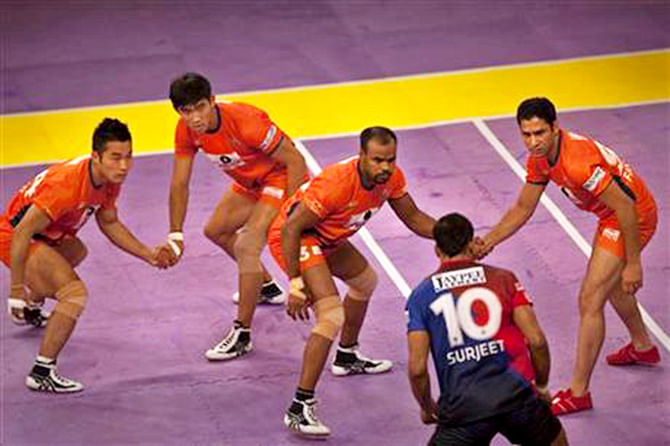 Bengal Warriors players try to catch a Dabang Delhi player (10) during their Pro Kabaddi League match in New Delhi, India on Aug 6, 2014. Photo: AP