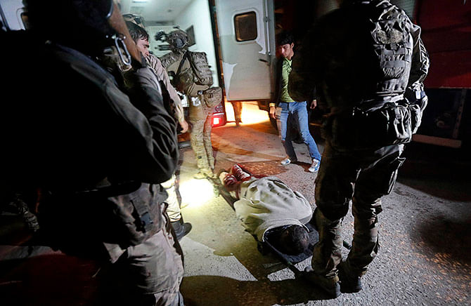 The dead body of a foreigner lies on the ground after a Taliban attack on a foreign aid workers' guest house in the Afghan capital of Kabul November 29, 2014. Photo: Reuters.