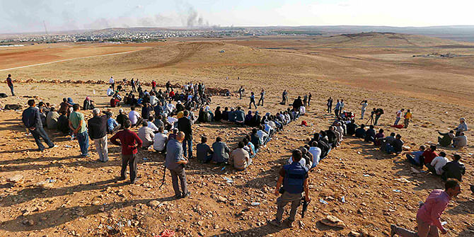 Turkish Kurds gather on the hill near the Mursitpinar border crossing on the Turkish-Syrian border near the southeastern town of Suruc in Sanliurfa province to support Kurdish fighters in Koban October 15, 2014. Photo: Reuters