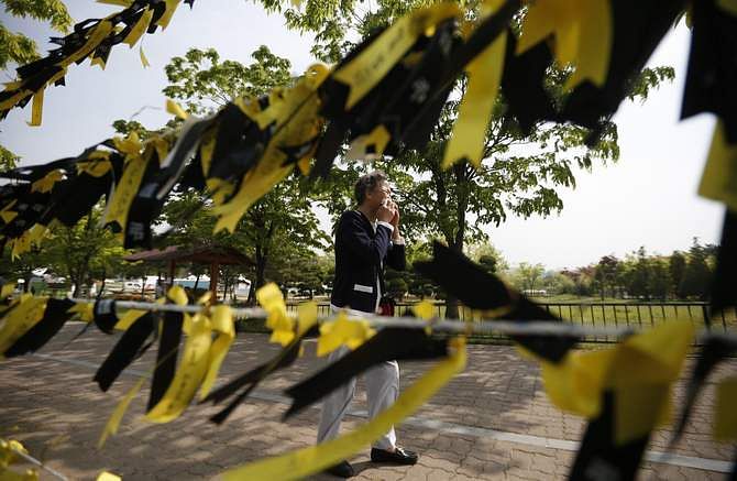 A mourner cries next to yellow ribbons dedicated to missing and dead passengers of sunken passenger ship Sewol, after paying tribute at the official memorial altar in Ansan May 2, 2014. Photo: Reuters 