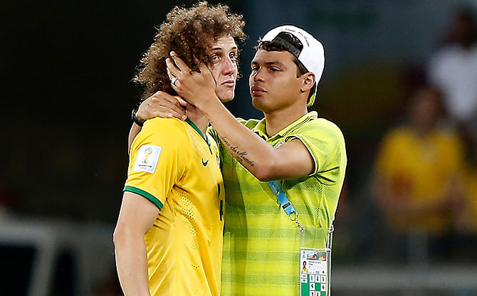 Brazil's defender Thiago Silva (R) conforts Brazil's defender David Luiz after the semi-final football match between Brazil and Germany on July 8, 2014. Photo: Getty Images