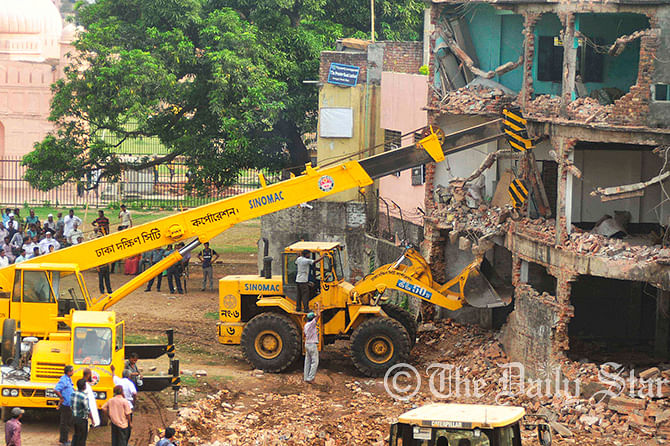 A bulldozer under the authority of Department of Archeology demolishes an illegal structure inside the historical Lalbagh Fort in Old Dhaka on Wednesday. Photo: Firoz Ahmed