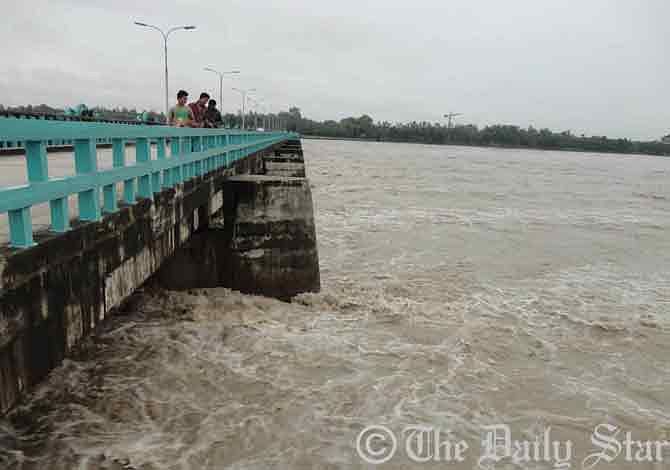 The river-water flows 30 centimetres above of danger mark at the Teesta Barrage point in Dowani village of Hatibanda upazila in Lalmonirhat Thursday morning. Photo: STAR