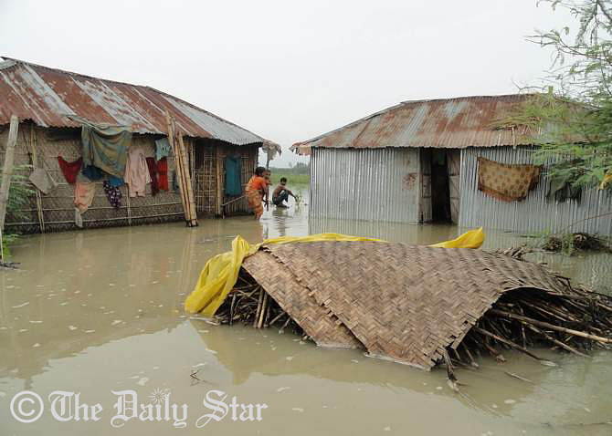 Residents leave their houses after water from the Teesta river floods houses in Gobordhan village in Aditmari upazila of Lalmonirhat district. Photo: STAR