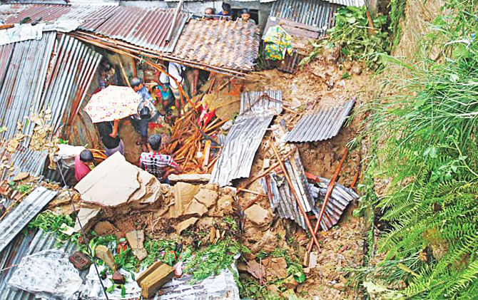 A mudslide induced by heavy rain destroys a home at the foot of a hill in Lalkhan Bazar in Chittagong city, killing two persons on July 28, 2013. Many families decided to stay in places identified as high risk to landslides even though the authorities concerned had asked them to move to safer places. Star file photo
