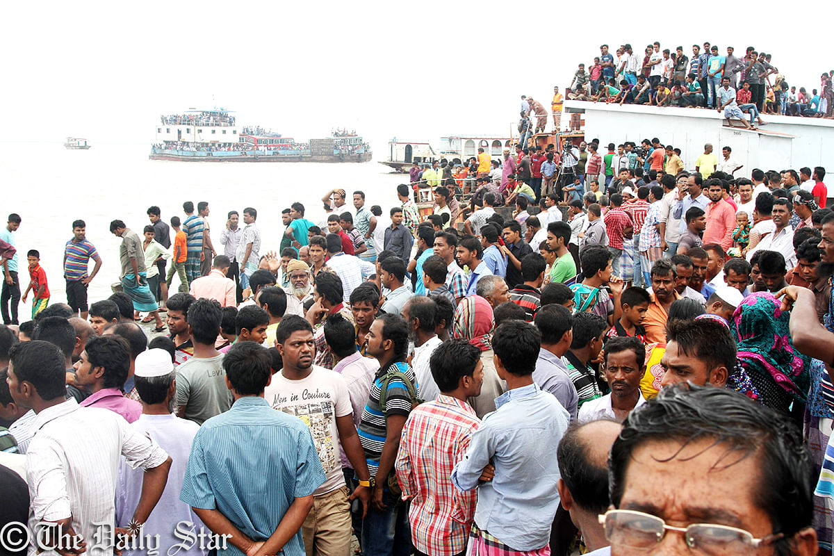 Several hundred people throng the bank of Padma Tuesday to see the rescue operation of the sunken launch. Photo: Sk Enamul Huq