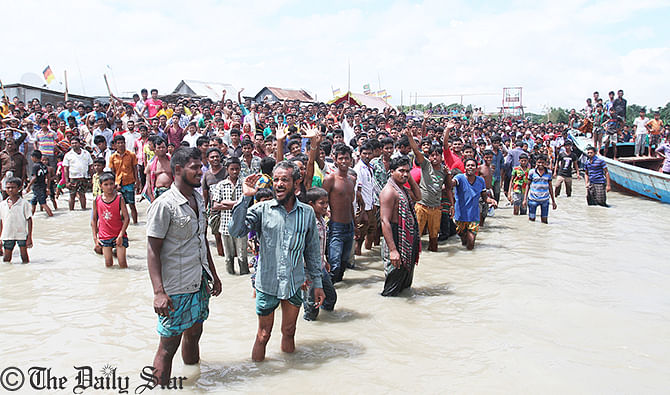 Several hundred relatives of victims and locals gather on the back of the Padma river at Mawa to see recovery of launch that sinks with 250 passengers on Monday. Photo: Anisur Rahman