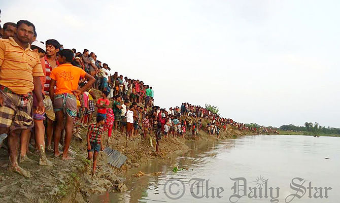 Relatives and villagers gather on the bank of Golachipa river Saturday afternoon where the launch capsize. Photo: Star