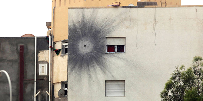 The impact of a rocket propelled grenade (RPG) marks the wall of a building on the road leading to the airport in Tripoli on May 19, 2014 following attacks by armed groups the previous day. Clashes broke out near the interim parliament in the capital, after a convoy of armoured vehicles entered the city from the airport road and headed for the General National Congress (GNC), adding to turmoil in Libya where a rogue general has launched an offensive against Islamists in the city of Benghazi. Photo: Getty Images