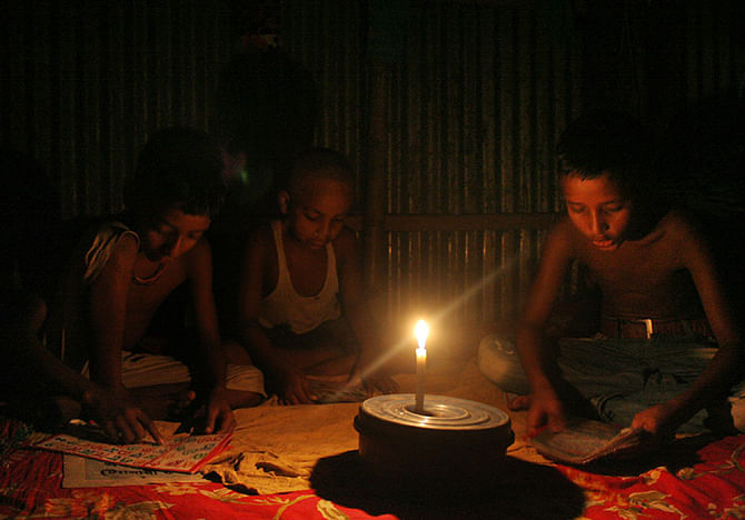 In this file photo taken from a house of Muslimbagh in Kamrangichar area of Dhaka shows children at are taking preparation for ensuing examination amid load shedding. Photo: Focus Bangla