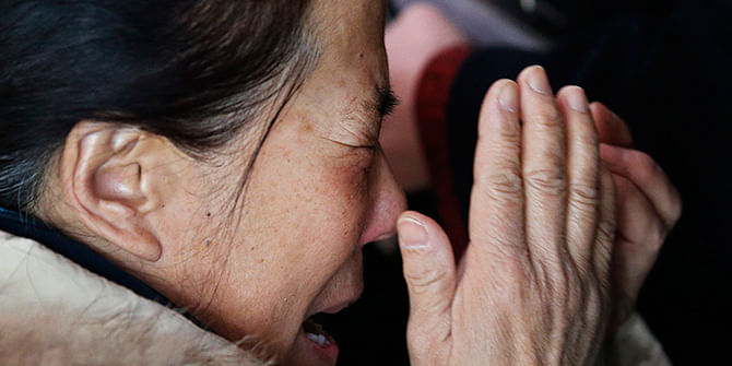 A woman (C), believed to be the relative of a passenger onboard Malaysia Airlines flight MH370, covers her face as she cries at the Beijing Capital International Airport in Beijing on March 8, 2014. Photo: Reuters A woman (C), believed to be the relative of a passenger onboard Malaysia Airlines flight MH370, covers her face as she cries at the Beijing Capital International Airport in Beijing on March 8, 2014. Photo: Reuters