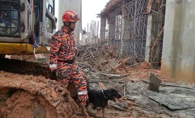 Fire and Rescue personnel are looking for the trapped victims who were buried under scaffolding which fell on them at the Ampang LRT site in Petaling Jaya of Malaysia on Wednesday . Photo: The Star