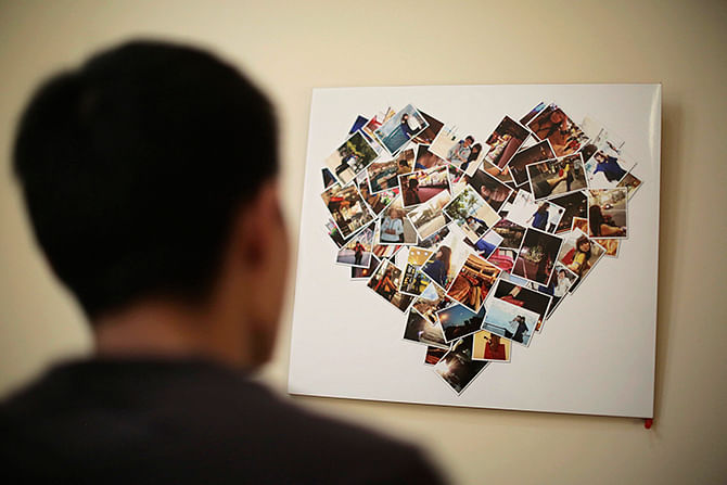 Zhang Zhiliang, 27-year-old Tianjin resident, looks at a board covered with pictures of his fiancee Li Jie, a passenger on board the missing Malaysia Airlines MH370, at their leased apartment in Tianjin, on Saturday. Li, who worked as an executive assistant at a firm in Beijing, went on a business trip to Malaysia on March 6. Zhang and Li were engaged earlier this year and planned to register for their marriage on March 23. Photo: Reuters
