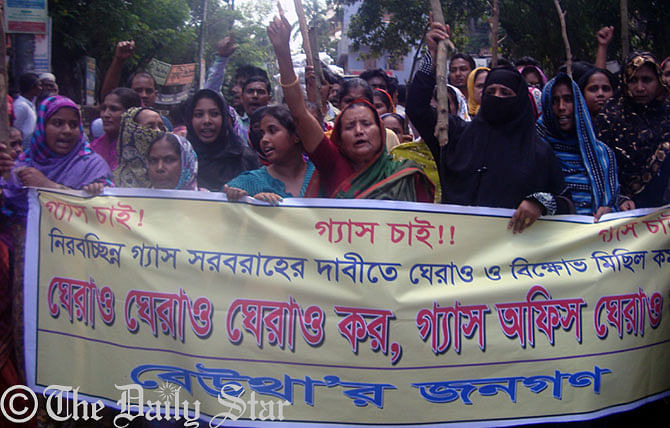 Manikganj people bring out a procession Tuesday morning demanding smooth gas supply in their households in the town. Photo: Star
