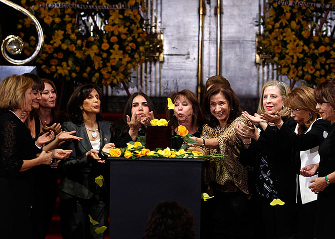 Women blow yellow rose petals over an urn containing the ashes of late Colombian Nobel laureate Gabriel Garcia Marque during a public viewing in the Palace of Fine Arts in Mexico City on Monday. Photo: Reuters