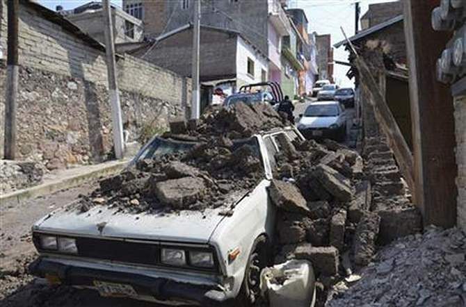 A parked car suffered damage when an adobe wall collapsed on it after a strong earthquake shook Chilpancingo, Mexico, Friday morning, April 18, 2014. A powerful magnitude-7.2 earthquake shook central and southern Mexico but there were no early reports of major damage or casualties. Photo: AP