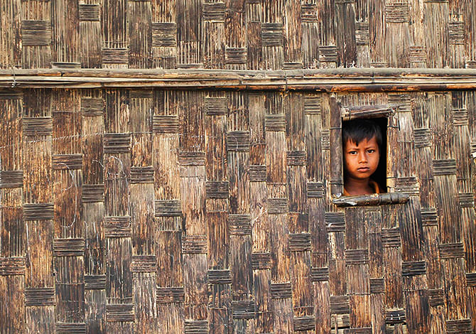 A boy looks from his temporary shelter at a Rohingya refugee camp as Myanmar's government embarks on a national census, in Sittwe on Wednesday. At least 20,000 people in displacement camps around Sittwe will run out of drinking water within 10 days, while food stocks will run out within two weeks, imperilling thousands more. Photo: Reuters