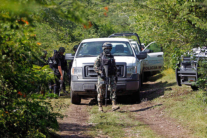 Soldiers guard an area where a mass grave was found, in Colonia las Parotas on the outskirts of Iguala, in Guerrero October 4, 2014. Photo: Reuters