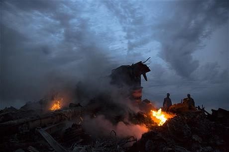People walk amongst the debris at the crash site of a passenger plane near the village of Hrabove, Ukraine, Thursday. Photo: AP