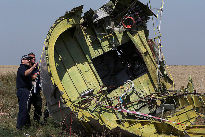 Members of a group of international experts inspect wreckage at the site where the downed Malaysia Airlines flight MH17 crashed, near the village of Hrabove (Grabovo) in Donetsk region, eastern Ukraine August 1, 2014. Photo: Reuters