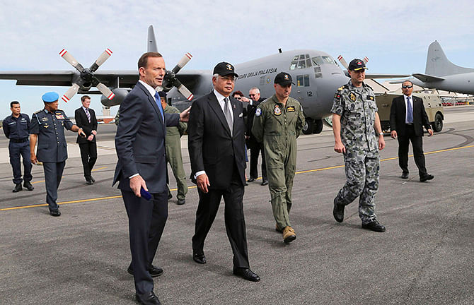 Australia's Prime Minister Tony Abbott (L) and Malaysia's Prime Minister Najib Razak tour the tarmac of RAAF Base Pearce with Australian Air Force Group Commander Craig Heap (3rd R) and Commodore Peter Leavy (2nd R), commander of join task force 658, near Perth on Thursday. Najib visited the Australian search base for missing Malaysia Airlines Flight MH370 as a nuclear-powered submarine joined the near-four week hunt that has so far failed to find any sign of the missing airliner and the 239 people on board. Photo: Reuters