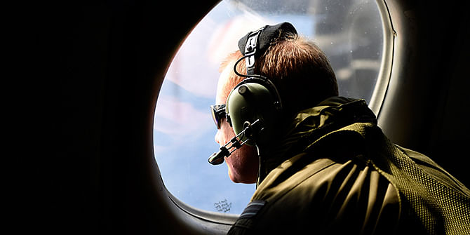 A crew member looks out an observation window aboard a Royal New Zealand Air Force (RNZAF) P3 Orion maritime search aircraft as it flies over the southern Indian Ocean looking for debris from missing Malaysian Airlines flight MH370 on Friday. Photo: Reuters