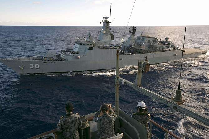Crew aboard the Australian Navy ship HMAS Success look over to the Royal Malaysian Navy ship KD LEKIU during a Replenishment at Sea evolution in the southern Indian Ocean during the continuing search for the missing Malaysian Airlines flight MH370 in this picture released by the Australian Defence Force April 7, 2014. Photo: Reuters 