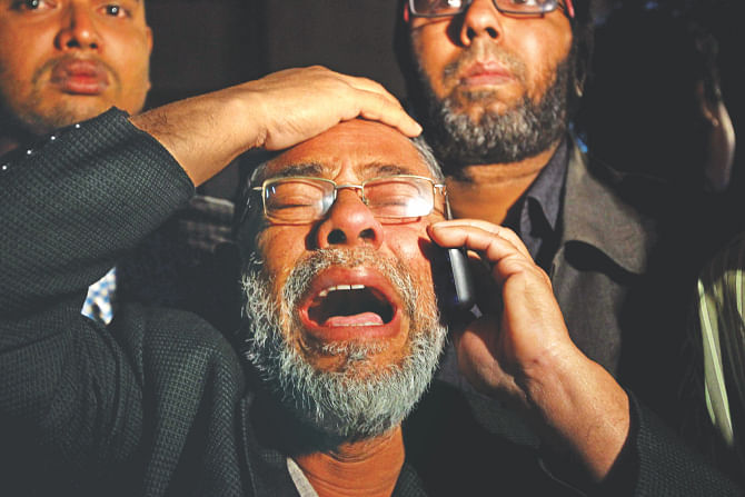 The father of a factory worker breaks down in tears and calls home to tell about the devastating fire at his daughter's factory at the capital's Mirpur-1 yesterday. Photo: Palash Khan