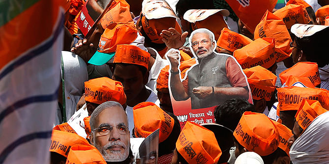 A supporter of Hindu nationalist Narendra Modi, prime ministerial candidate for India's main opposition Bharatiya Janata Party (BJP), carries a cut-out as they wait for Modi's arrival to file nomination papers for the general elections in the northern Indian city of Varanasi on Thursday. Photo: Reuters
