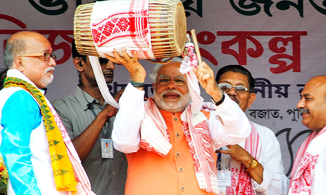 Hindu nationalist Narendra Modi (C), the prime ministerial candidate for India's main opposition Bharatiya Janata Party (BJP), plays a dhol, an Indian musical instrument, during an election campaign rally in Mangaldoi in the northeastern Indian state of Assam April 19, 2014. Photo: Reuters