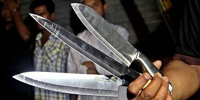 This Star photo taken on August 28, 2014 shows a law enforcer is holding three knives which were recovered from the scene of triple murder at Moghbazar in Dhaka.