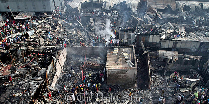 A cihld's body has been recovered from the fire devastated site of a rickshaw garage and adjacent shanties in Moghbazar area of the capital Saturday. Photo: Anisur Rahman