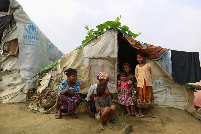 A family sits in front of their temporary shelter at a Rohingya refugee camp as Myanmar's government embarks on a national census, in Sittwe April 2, 2014. At least 20,000 people in displacement camps around Sittwe will run out of drinking water within 10 days, while food stocks will run out within two weeks, imperilling thousands more. Photo: Reuters