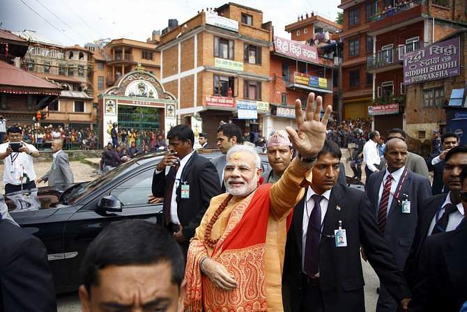 India's Prime Minister Narendra Modi waves at supporters waiting to greet him at the premises of Pashupatinath Temple in Kathmandu August 4, 2014. Photo: Reuters
