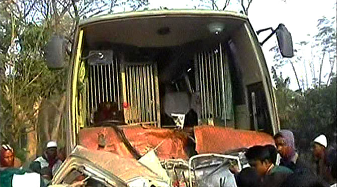 Locals crowd around the wreckage of a bus which rammed into a human hauler killing four people and injuring six in Sadar upazila of Natore this morning. Photo: TV grab