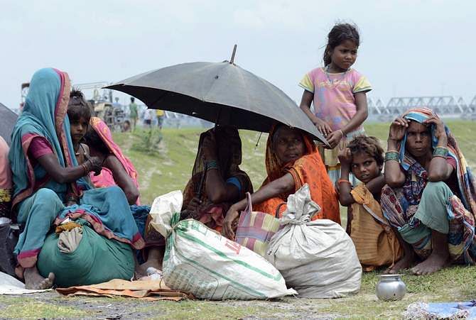 Villagers with their belongings sit in a relief camp after their evacuation at Supaul district in the eastern Indian state of Bihar August 3, 2014. Photo: Reuters