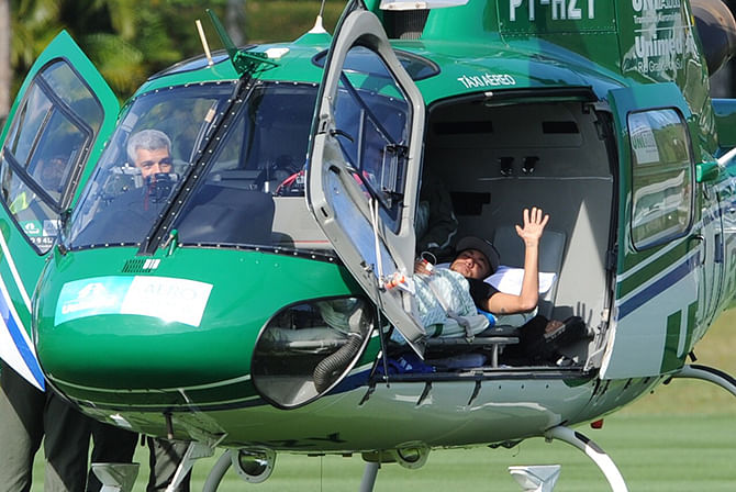 Brazilian striker Neymar waves on July 5, 2014 from inside the helicopter that will transport him from Teresopolis, Rio de Janeiro State, Brazil to his residence in Guaruya. Injured Brazil star Neymar departed his team's training base in Terespolis in a helicopter on Saturday and headed home to Sao Paulo, after his World Cup ended in agony on Friday night. Photo: AFP/ Getty Images