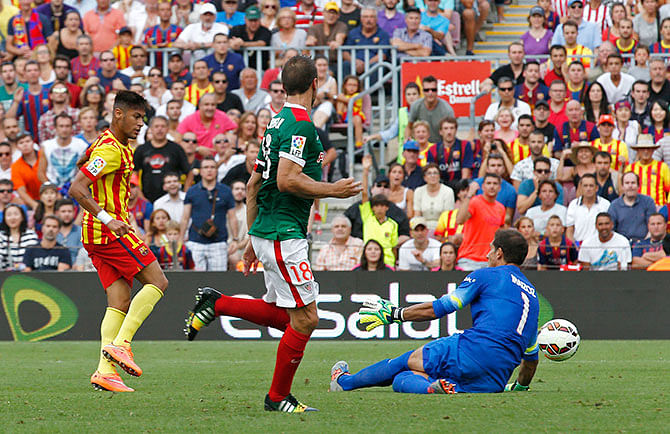 Barcelona's Neymar (L) scores a goal against Athletic Club's goalkeeper Gorka Iraizoz (R) during their Spanish first division soccer match at Nou Camp stadium in Barcelona September 13, 2014. Photo: Reuters 