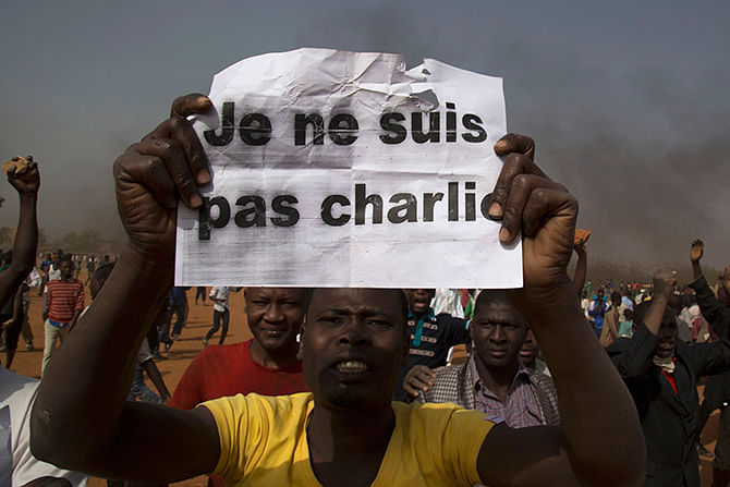 A man holds a copy of the Koran during a protest against Niger President Mahamadou Issoufou's attendance last week at a Paris rally in support of French satirical weekly Charlie Hebdo, which featured a cartoon of the Prophet Mohammad as the cover of its first edition since an attack by Islamist gunmen, in Niamey January 17, 2015. Photo: Reuters
