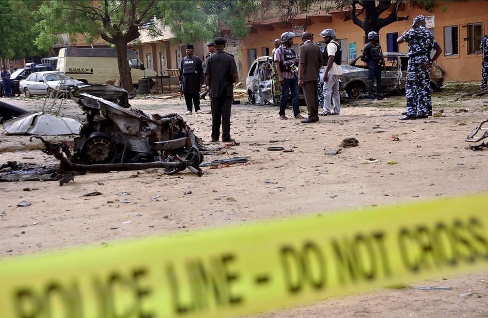 Policemen stand near damaged vehicles in Sabon Gari, Kano, after a Boko Haram car bomb attack killed five earlier this year. Photo: Reuters