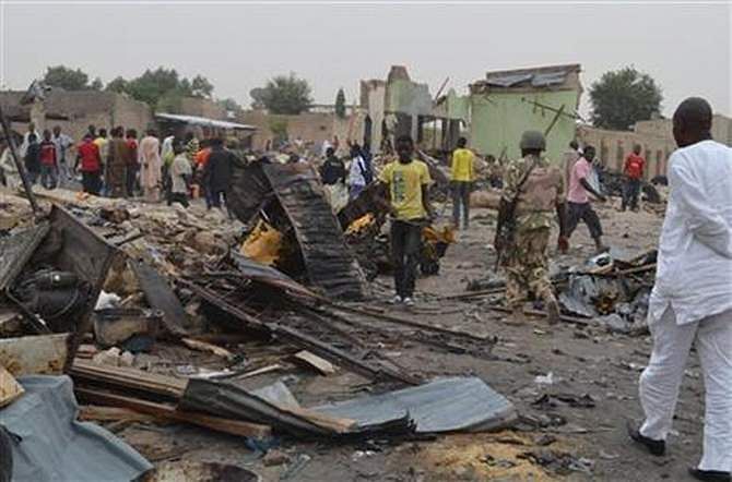 People gather at the site of a twin car bomb explosion in Maiduguri, Nigeria, March 2, 2014. Photo: AP/File