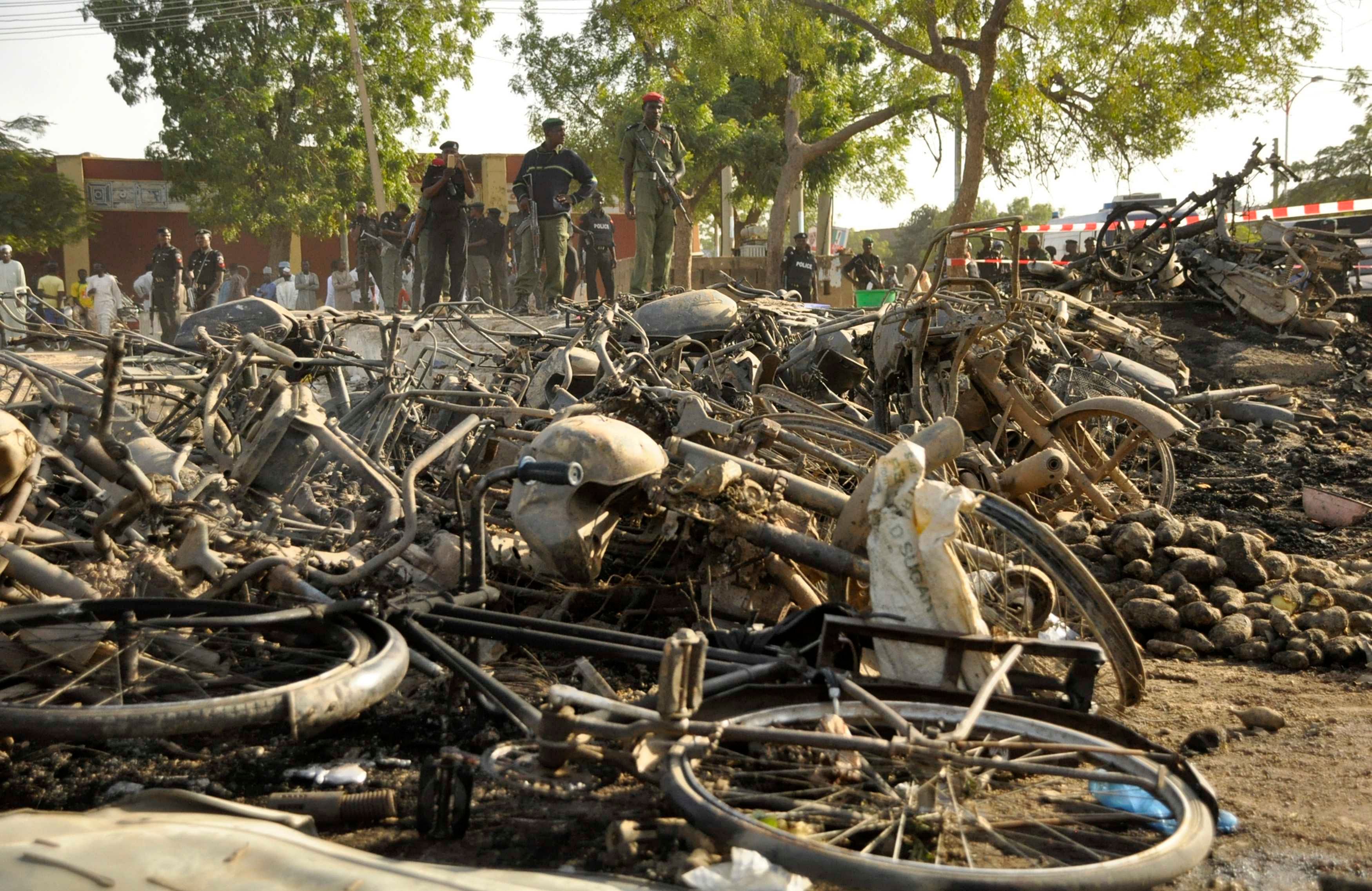 Police officers stand near wreckage at a scene of multiple bombings at Kano Central Mosque November 28. Photo: Reuters 